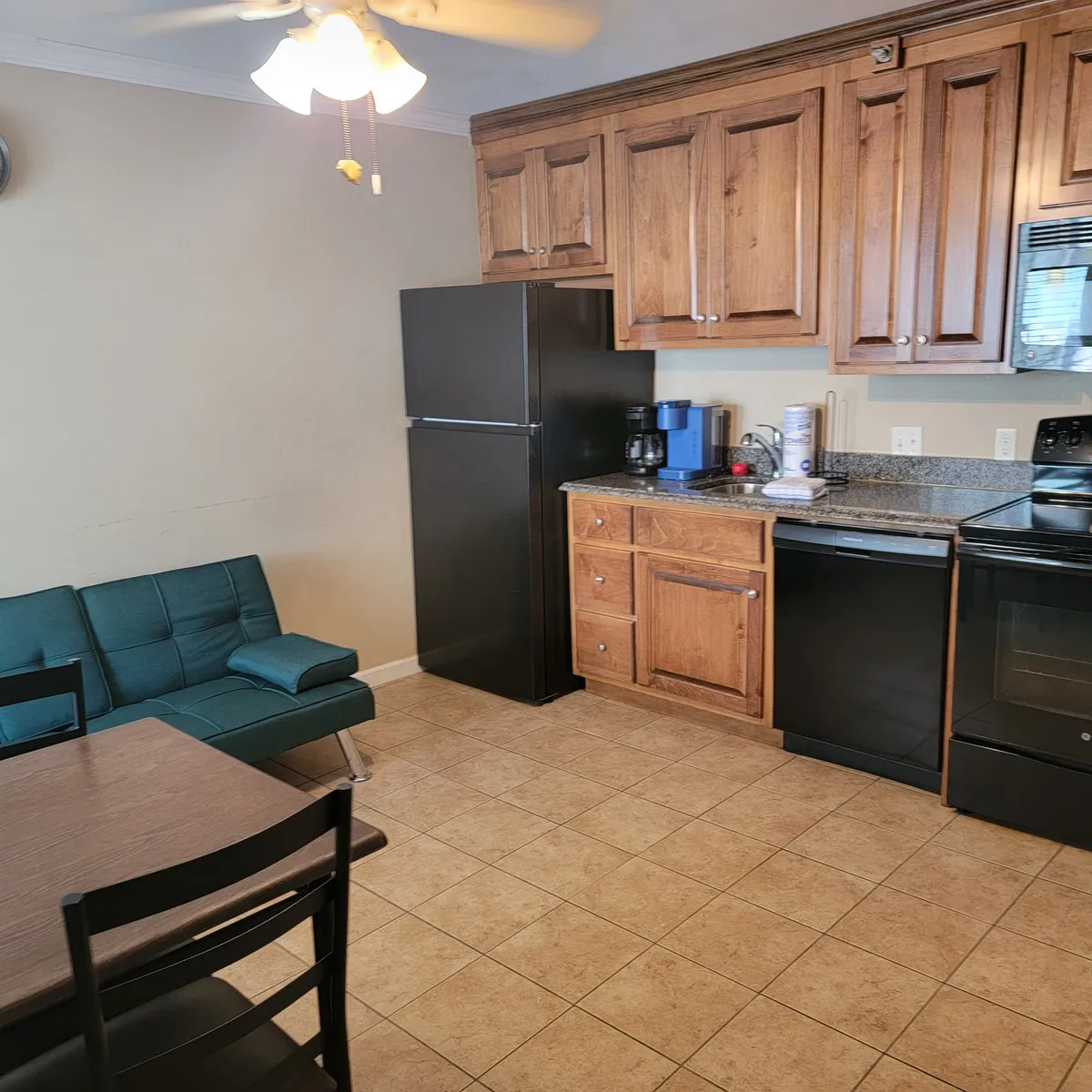 This image features an inviting, integrated kitchen, dining table, and sofa seating in a single shot. The relaxed mood and open plan design highlights how the living, dining, and kitchen spaces flow together, ideal for shared activities, conversations, and group meals.